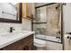 Updated bathroom featuring shower with tile surround, sliding door, and wood vanity at 43343 E Arkansas Pl, Bennett, CO 80102