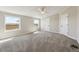 Bedroom with plush carpeting, neutral walls, ceiling fan, and windows offering outdoor views at 43343 E Arkansas Pl, Bennett, CO 80102