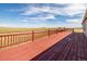 Expansive deck featuring a red wooden fence and floor at 43343 E Arkansas Pl, Bennett, CO 80102
