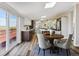 A modern dining area with wood table and chairs, a sliding glass door to the deck, and an open view of the kitchen at 43343 E Arkansas Pl, Bennett, CO 80102