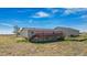 Exterior view of the house from the back with a deck and stairs to the yard at 43343 E Arkansas Pl, Bennett, CO 80102