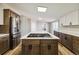 Kitchen island with marble countertop with a built-in cooktop and stainless appliances at 43343 E Arkansas Pl, Bennett, CO 80102