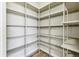A walk-in pantry boasts ample shelving for organized storage and features wood-look flooring at 43343 E Arkansas Pl, Bennett, CO 80102