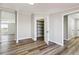 Spacious room with multiple entrances, storage shelves, and hardwood floors at 43343 E Arkansas Pl, Bennett, CO 80102
