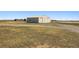 Large shed featuring tan metal siding and a dirt driveway at 43343 E Arkansas Pl, Bennett, CO 80102