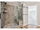 Beautifully tiled shower with glass enclosure, built-in bench, and shelves for storage at 43343 E Arkansas Pl, Bennett, CO 80102