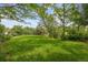 Large, grassy backyard framed by mature trees, providing a serene and private outdoor space at 6334 Cherokee Dr, Sedalia, CO 80135