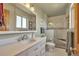 Bright bathroom featuring a white vanity, a glass-enclosed shower with a built-in seat, and updated fixtures at 6334 Cherokee Dr, Sedalia, CO 80135