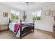 Bright bedroom with neutral carpet, decorative bed, and bright windows overlooking mature trees at 6334 Cherokee Dr, Sedalia, CO 80135