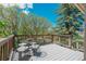 Wood deck with seating offers a relaxing outdoor space and views of the mature landscaping at 6334 Cherokee Dr, Sedalia, CO 80135