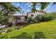 Charming home exterior featuring a spacious deck and lush, landscaped backyard on a sunny day at 6334 Cherokee Dr, Sedalia, CO 80135