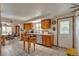 Well-lit kitchen with tiled floors, wooden cabinets, and an open design connected to the dining area at 6334 Cherokee Dr, Sedalia, CO 80135