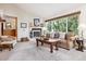 Bright living room featuring a classic fireplace, comfortable seating, and large windows with views of the outdoors at 6334 Cherokee Dr, Sedalia, CO 80135