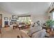 Cozy living room showcasing a brick fireplace, comfortable seating, and ample natural light from large windows at 6334 Cherokee Dr, Sedalia, CO 80135