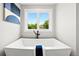Modern soaking tub with stylish fixtures and a large window with beautiful views at 1500 S Elizabeth St, Denver, CO 80210