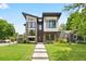 Modern two-story home with a combination of brick, siding, and large windows, complemented by a green lawn at 1500 S Elizabeth St, Denver, CO 80210