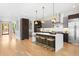 Open kitchen featuring an island with seating, modern appliances, and dark wood cabinetry at 1500 S Elizabeth St, Denver, CO 80210