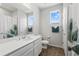 Well-lit bathroom with a modern vanity, sleek fixtures, and a decorative shower curtain at 5230 Periwinkle Way, Henderson, CO 80640