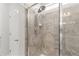 Close up of the walk-in shower with glass enclosure and brushed nickel shower head at 5230 Periwinkle Way, Henderson, CO 80640