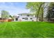 The spacious backyard features a lush green lawn and a patio area for outdoor gatherings at 5853 S Havana Ct, Englewood, CO 80111