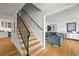 Bright entryway with hardwood floors, a staircase with iron railings, and a glimpse into the living room at 5853 S Havana Ct, Englewood, CO 80111