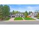 Charming two-story home with a lush green lawn, a driveway, and mature trees at 5853 S Havana Ct, Englewood, CO 80111
