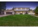Inviting two-story home with manicured lawn, dark garage door, and a cozy front porch bench at 5853 S Havana Ct, Englewood, CO 80111