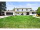 Inviting two-story home with manicured lawn, dark garage door, and a cozy front porch bench at 5853 S Havana Ct, Englewood, CO 80111