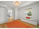 Inviting foyer with hardwood floors, decorative light fixture and bench seating with a cushioned top at 5853 S Havana Ct, Englewood, CO 80111