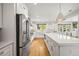 Bright kitchen featuring white cabinets, stainless steel appliances, a large island, and hardwood flooring at 5853 S Havana Ct, Englewood, CO 80111
