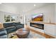 Cozy living room with a modern fireplace, plush sofa, and large window with natural light at 5853 S Havana Ct, Englewood, CO 80111