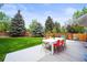 Back patio with a colorful table and chairs, ideal for outdoor dining and relaxation in a serene setting at 5853 S Havana Ct, Englewood, CO 80111
