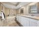 Serene bathroom boasts dual sinks, a tub, neutral tiling, and elegant framed mirrors at 4505 S Yosemite St # 106, Denver, CO 80237