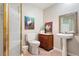 Compact bathroom with a pedestal sink, decorated with colorful rooster artwork at 4505 S Yosemite St # 106, Denver, CO 80237