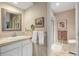 Bright bathroom features a vanity with framed mirror and a view into a shower at 4505 S Yosemite St # 106, Denver, CO 80237