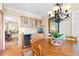 A chandelier hangs over a wood table near built-in cabinets with wine storage in the dining area at 4505 S Yosemite St # 106, Denver, CO 80237