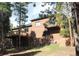 Exterior shot of back of a house with a deck and a stone foundation and accents at 9274 Sandy Ln, Conifer, CO 80433