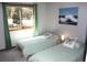 Bedroom featuring two twin beds with patterned linens and a bright window at 9274 Sandy Ln, Conifer, CO 80433