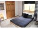 Neutral bedroom featuring a low platform bed and natural light through the window at 9274 Sandy Ln, Conifer, CO 80433