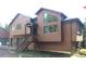 Two-story house with wood siding, stairs leading to the front door, and unique geometric windows at 9274 Sandy Ln, Conifer, CO 80433