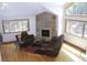 Bright living room featuring a stone fireplace, hardwood floors, and large windows with forest views at 9274 Sandy Ln, Conifer, CO 80433