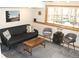 Living room featuring a sofa, chairs, a coffee table, and natural lighting from the window at 9274 Sandy Ln, Conifer, CO 80433