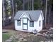 Charming cottage-style shed with white siding, green trim, and a gabled roof at 9274 Sandy Ln, Conifer, CO 80433