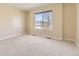 Spacious bedroom with neutral walls and carpet flooring, with a large window offering natural light at 19406 E Maplewood Pl, Aurora, CO 80016