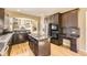 Modern kitchen with dark cabinetry, center island, and stainless steel appliances at 19406 E Maplewood Pl, Aurora, CO 80016