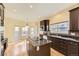 Modern kitchen featuring dark cabinetry, granite countertops, and a center island at 19406 E Maplewood Pl, Aurora, CO 80016