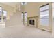 Bright living room with tall windows, cozy fireplace, and neutral carpeting at 19406 E Maplewood Pl, Aurora, CO 80016