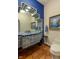 Unique bathroom featuring blue-tiled accents, decorative artwork, and tiled flooring at 7022 Secrest Ct, Arvada, CO 80007