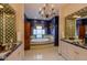 Well lit bathroom features decorative tile accents, a tub, dual vanities, and private windows at 7022 Secrest Ct, Arvada, CO 80007