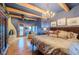 Comfortable bedroom boasts wood beam ceiling, chandelier, fireplace, and private balcony at 7022 Secrest Ct, Arvada, CO 80007